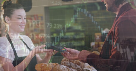 Image of data processing over caucasian man using credit card to make payment at a cafe