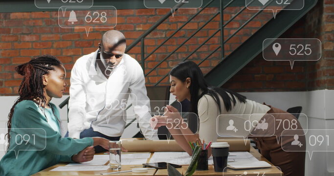 Anmation of social media icons floating over diverse colleagues discussing over a plan at office