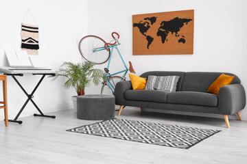 Interior of cozy living room with sofa, bicycle and synthesizer near white wall