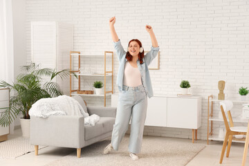 Young woman in headphones dancing at home