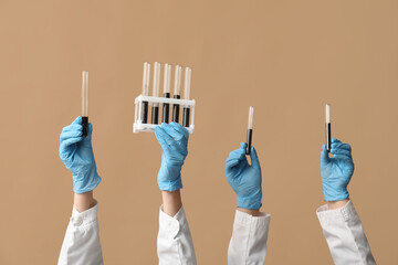 Scientist's hands holding test tubes with soil and stand on brown background