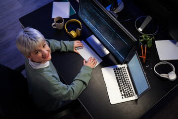 Female programmer working in office at night, top view