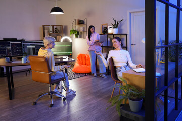 Team of female programmers working in office at night