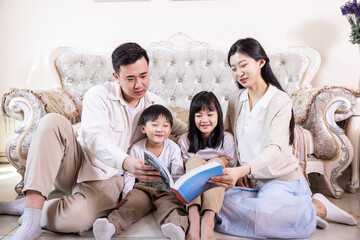 A family of four reading and playing together in the living room