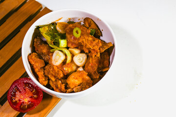 sweet and sour shrimp dishes in a porcelain bowl and on a wooden coaster