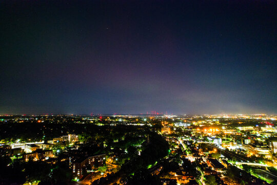 An aerial view of the Aurora Borealis over Cleveland, Ohio on May 5th, 2024. Downtown is in view, the bright lights of the city subduing the aurora's colors.