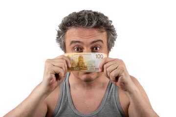 A gray-haired, shaggy, unshaven middle-aged man in a sleeveless T-shirt holds a 100 Russian ruble...