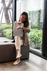 Young thoughtful Asian business woman working in modern office