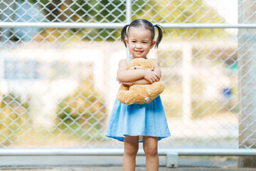 Playful happy Asian two-year-old female toddler, immersed in wonders of toddlerhood, delights in...