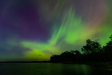 Northern Lights over Lake Burtnieks. Aurora Borealis or Northern Lights Latvia. Aurora reflection in the water at night