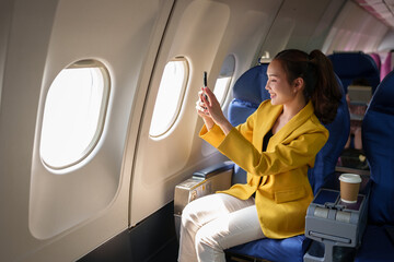 Young woman, business woman in a yellow suit is using a smartphone to take a photo of the scenery....