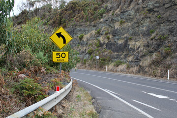 Great Ocean Road with speed limit sign winding through a mountain in Victoria, Australia