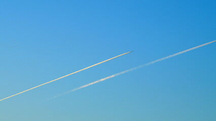 Airplane High In The Blue Sky. Plane With Vapor Stripes. Diagonal White Jet Trail In The Blue Sky....