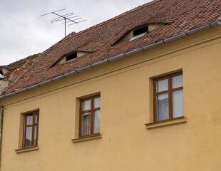 Red clay tiled roof with eye-like windows in the old town of Sibiu, Transylvania, Romania. Old houses with eyes are symbol of Sibiu