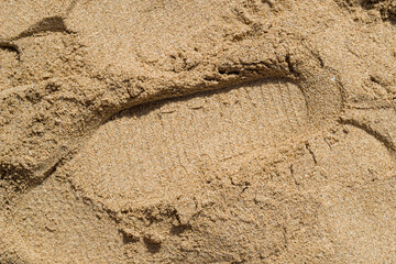 footprints on clean sand of beach. Close up, beach sand texture. Beach sand texture in summer sun