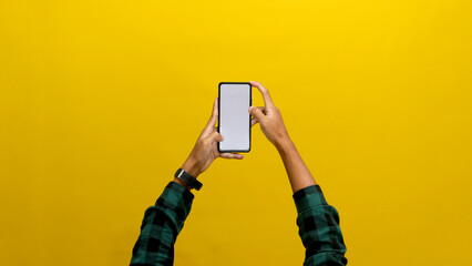 Hand Holding a Phone with a Blank White Screen, Isolated on a Yellow Background