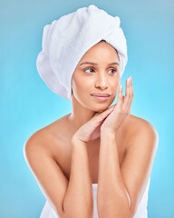 Skincare, beauty or Indian woman with towel in studio facial glow with natural dermatology cosmetics. Morning, blue background and face of girl model thinking of health ideas, cleaning or wellness