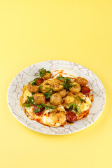 young fried potatoes with sauce and fried egg in a plate