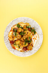 young fried potatoes with sauce and fried egg in a plate