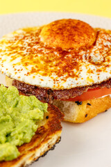 sandwich with egg, guacamole and beef patty