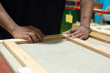 Hands of a carpenter gluing two paderas