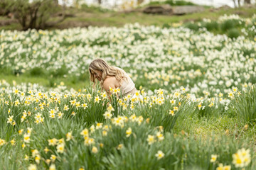 Woman smelling flowers in a daffodil field