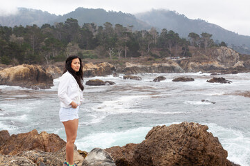 woman standing on rocks near the ocean