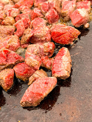 Steak cubes sizzling on a Blackstone grill