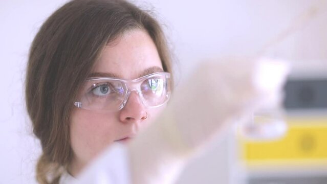 scientist female working with lab glasses and lab gloves