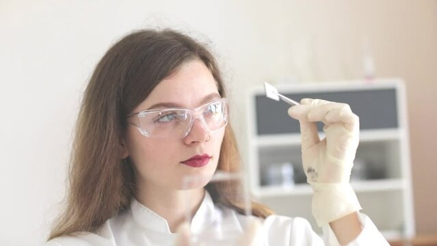 scientist female working with lab glasses and lab gloves
