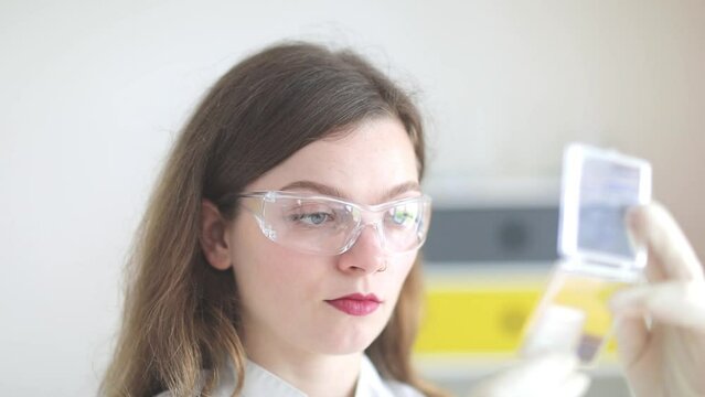 scientist female working with lab glasses and lab gloves