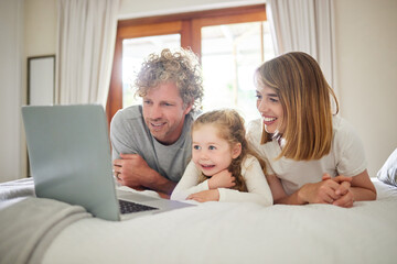 Obraz premium Child, parents and relax with laptop on bed, house and bonding, watching movie or streaming online for entertainment. Family, girl and together on internet with care, subscription or cartoon film