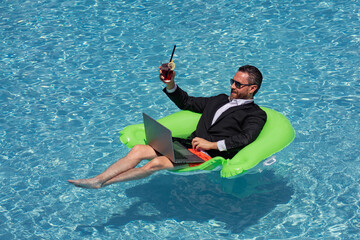 Successful business man floating in suit in pool water. Summer vacations and travel concept. Funny...