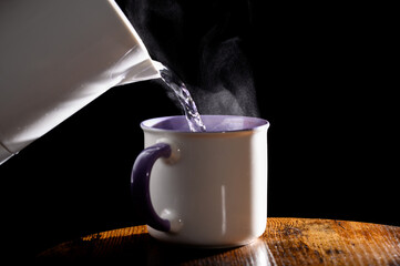 Zalewać kawę w kubku gorąca wodą, parującym wrzątkiem, z czajnika