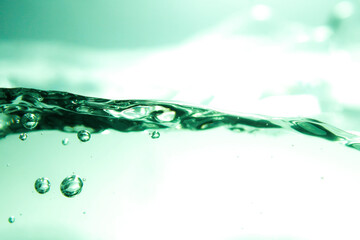 Image of water waves and clear green air bubbles.
