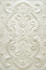 A white tile with intricate designs on it.