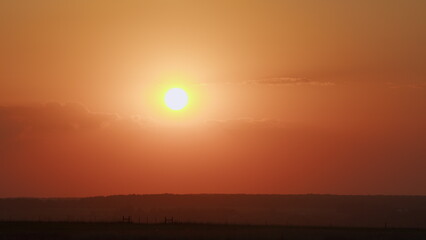 Awesome epic cloud space. Big red hot sun in warm air distortion above horizon. Timelapse.