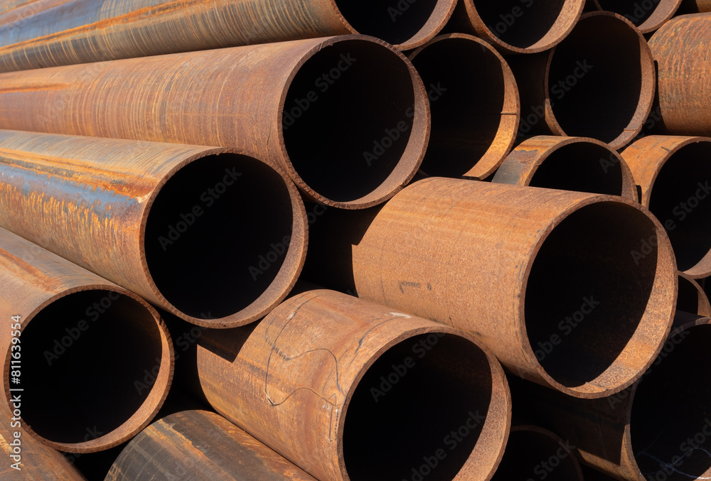 Wall mural rusty steel pipes stacked on a construction site