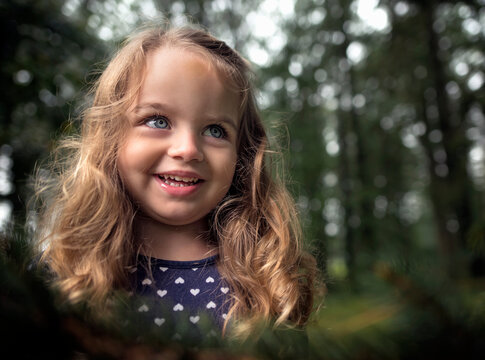 Beautiful happy little girl blue eyes blond curls smiling