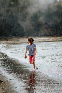 Young girl runs from waves at Black Beach, New Brunswick