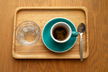  Hot ceramic green coffee cup with drinking water on old wooden table in nature background.