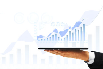 A person's hand holding a tablet with a digital graph, overlaid on a white background with financial symbols, symbolizing business growth