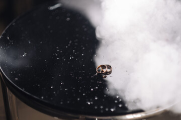 Two precious white gold rings on black leather. Silver rings with white highlights on a black background.