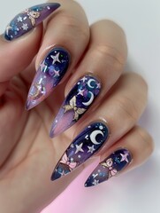 A person holding up a nail with stars and moons.
