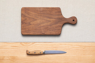 Handmade walnut wood cutting board and knife lie on the table. cutting board with knife. cutting board and knife.