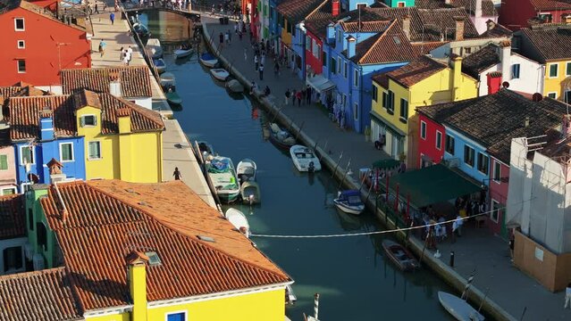 Aerial view of boats on the sides of a canal near the colourful houses of Burano island, Italy