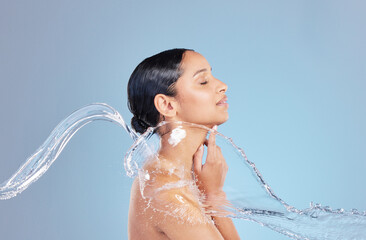 Woman, water splash and shower with cleaning in studio for hygiene, bacteria and dirt by blue background, Girl, person and model for hydration, profile and stop germs for healthy body for skincare