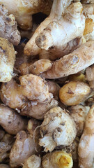 Close up pile of tasty fresh ginger sold at the market as a background.