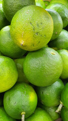 Close up pile of tasty fresh limes sold at the market as a background.