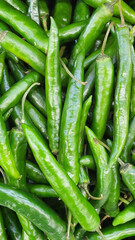 Close up pile of fresh green chilli placed together in local market as a background.	